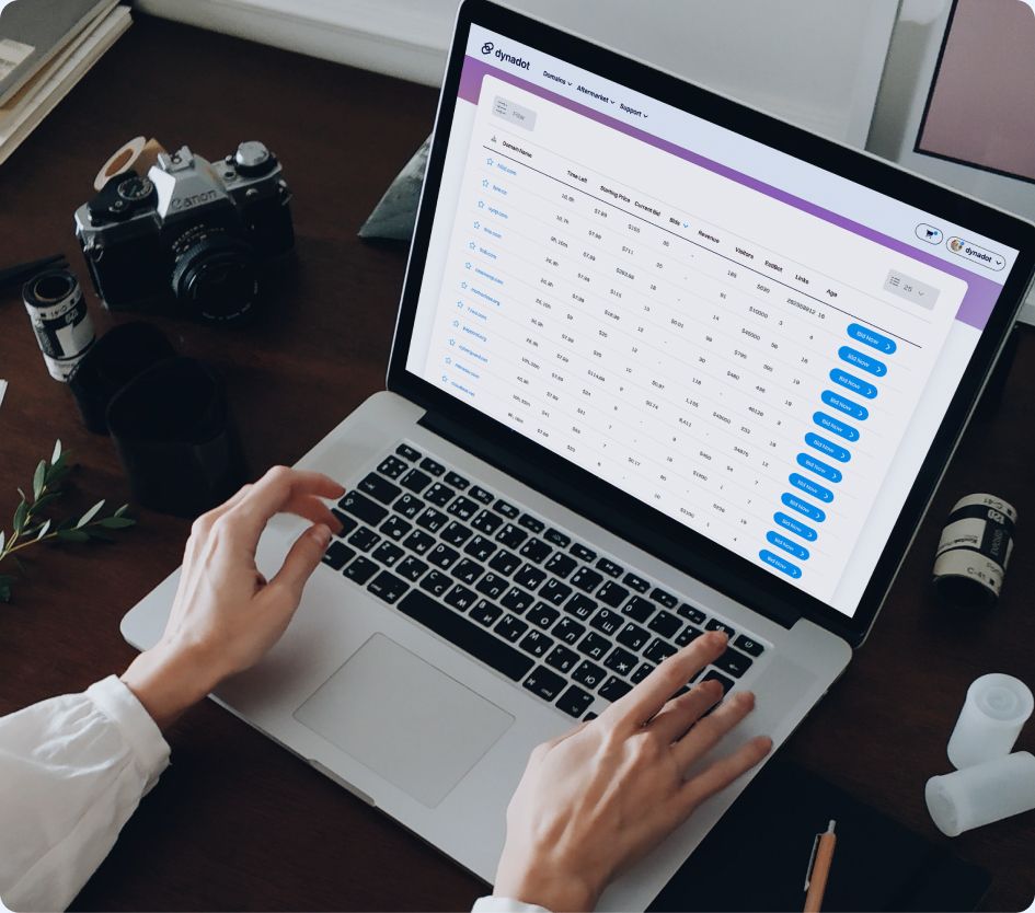 User managing domains in the Dynadot dashboard on a laptop.