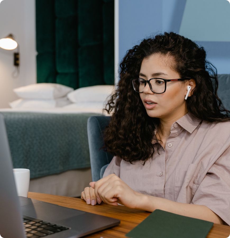 Person wearing glasses and wireless earbuds working on a laptop at a desk, shown alongside a “How to Become a Reseller”